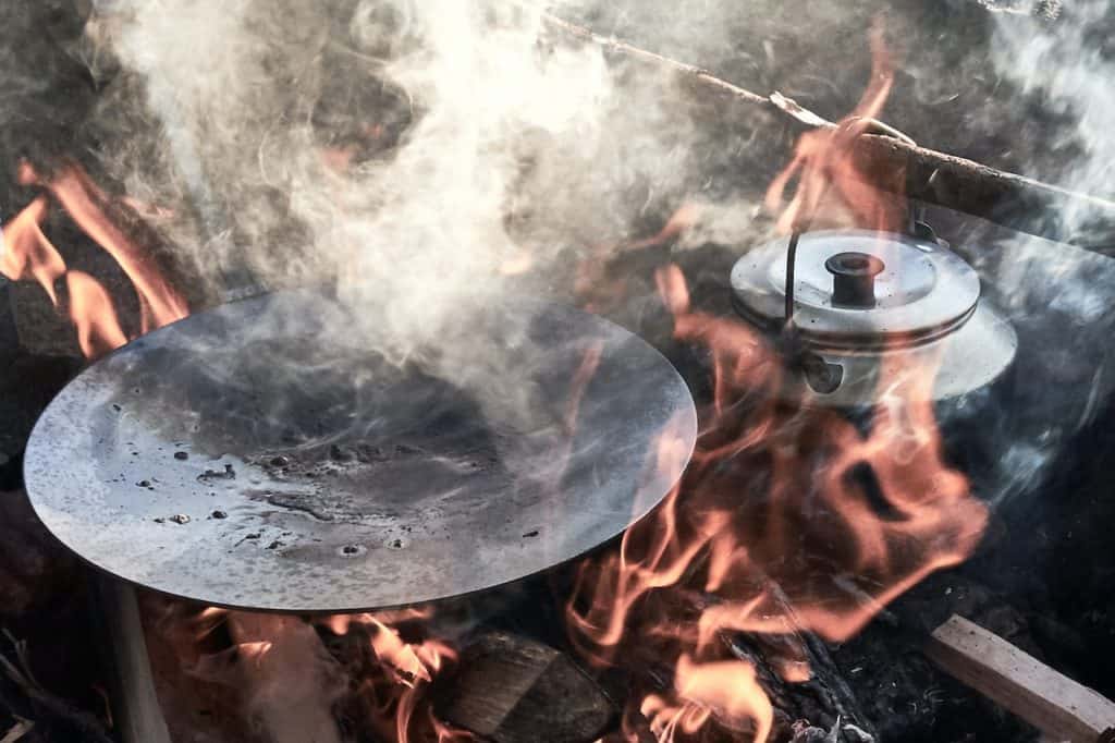 old pan on campfire and coffee pot